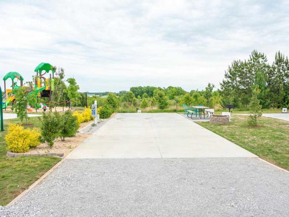 A gravel site next to the playground at HERITAGE ACRES RV PARK