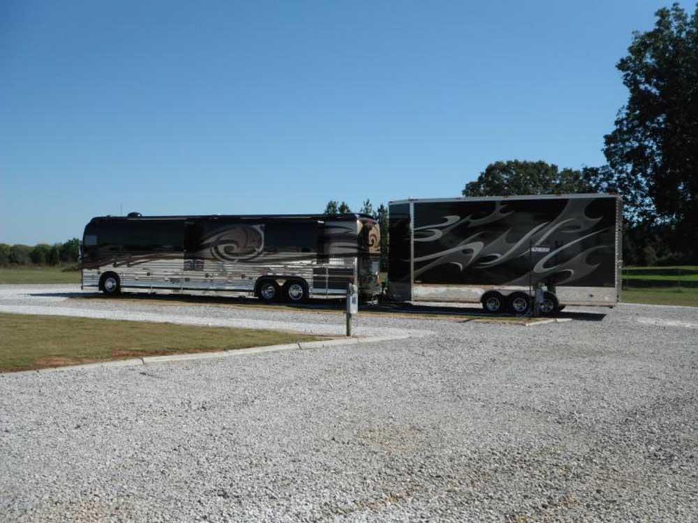 A motorhome pulling a trailer at HERITAGE ACRES RV PARK