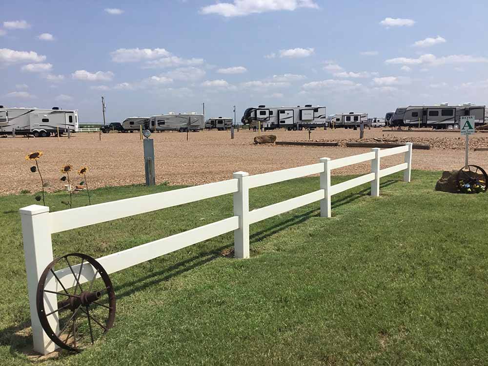 A white fence in the middle of grass at WESTERN STAR RV RANCH