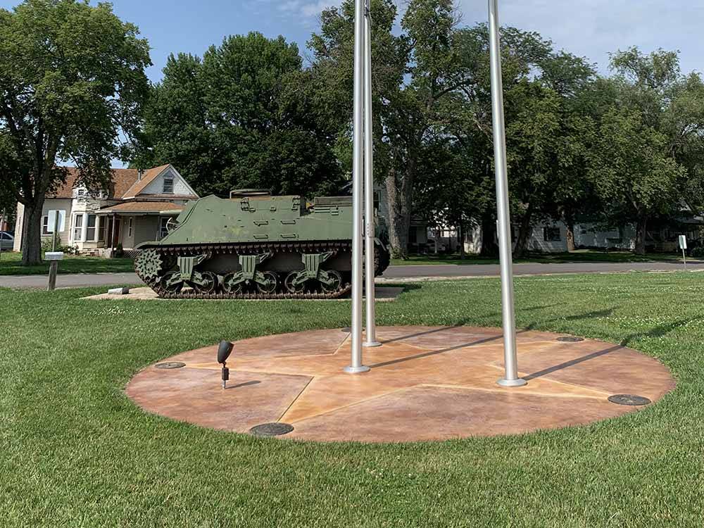 Flag poles and vintage military tank at BAILEY'S RV RESORT