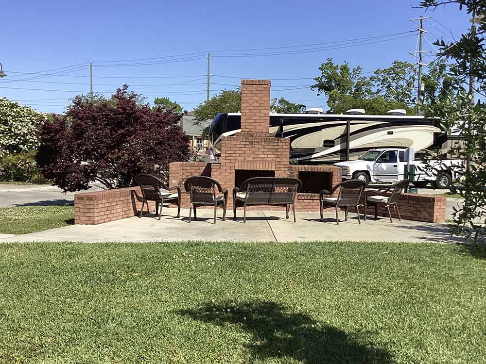 An outdoor fireplace with seating at MAJESTIC OAKS RV RESORT