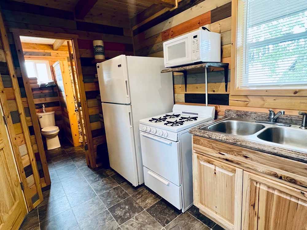 The kitchen and restroom of one of the cabins at KLONDIKE RV PARK & COTTAGES