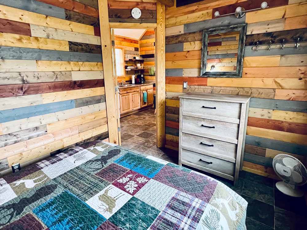 The bedroom and kitchen of the cabin at KLONDIKE RV PARK & COTTAGES