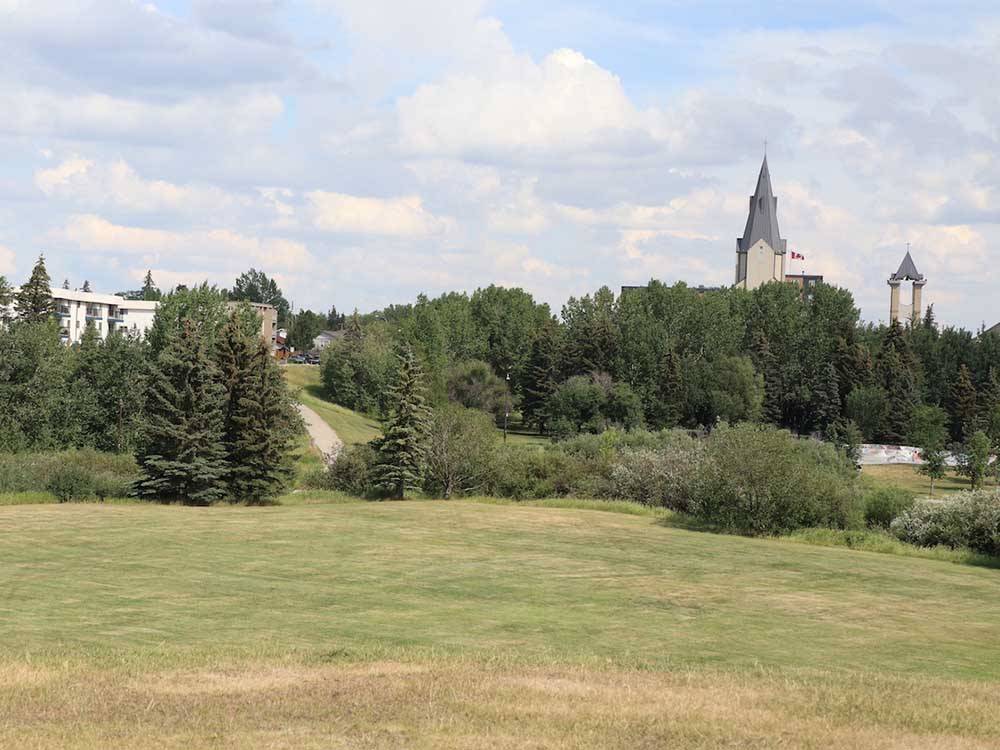 A sprawling meadow, forest and spires in the distance at GRANDE PRAIRIE REGIONAL TOURISM ASSOCIATION