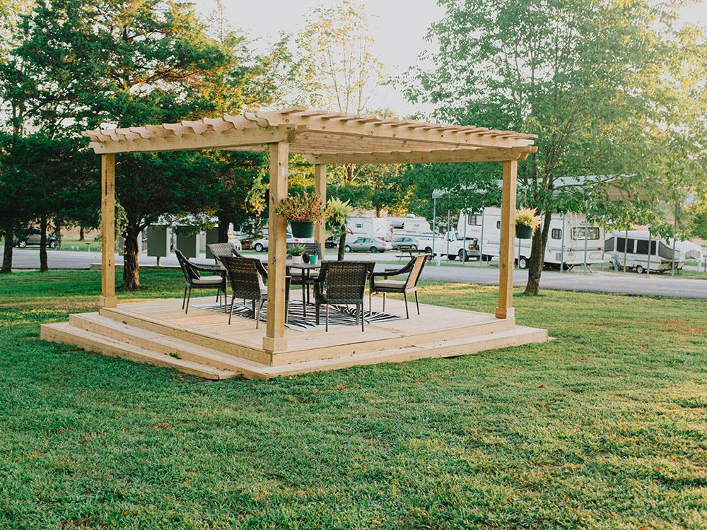 Wicker chairs and table under a pergola at SILVER SPRINGS RV PARK