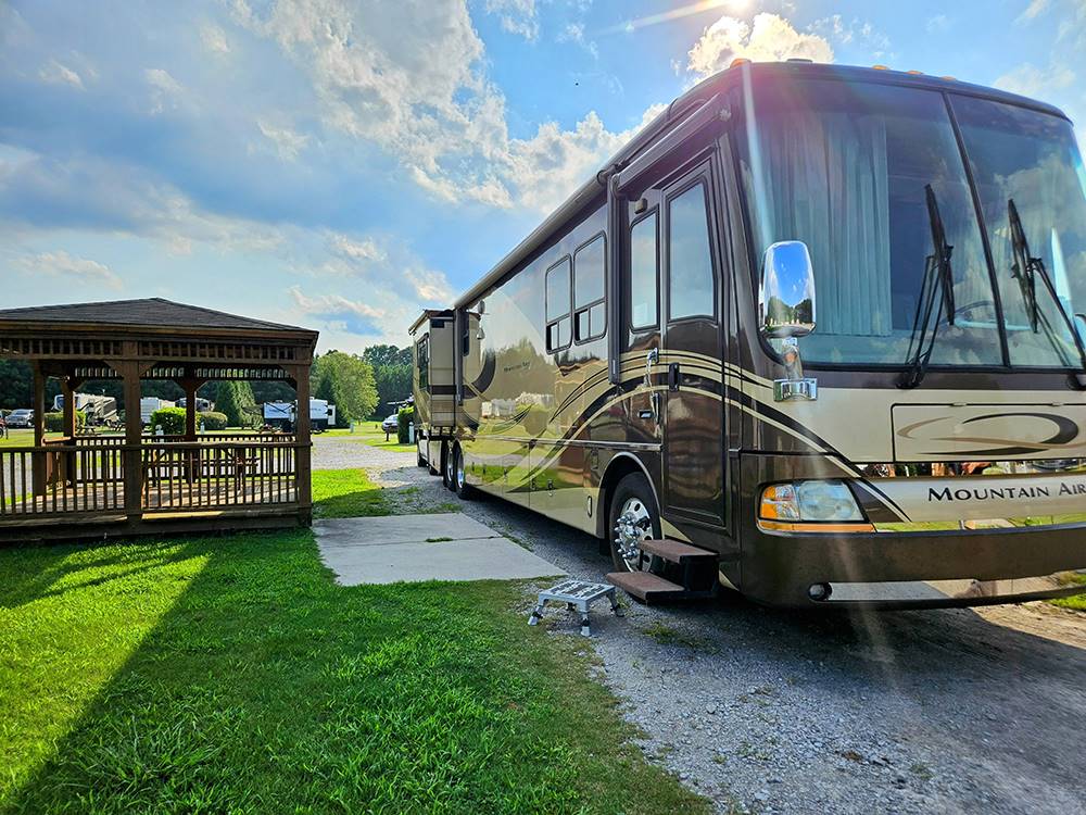 Class A parked at a site with a covered sitting area at The RV Resort at Carolina Crossroads