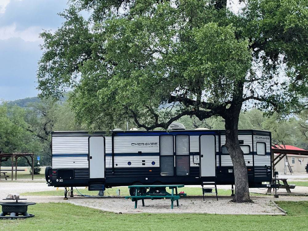 RV sites with fire pit and table at STARS OVER TEXAS RV PARK - FRIO