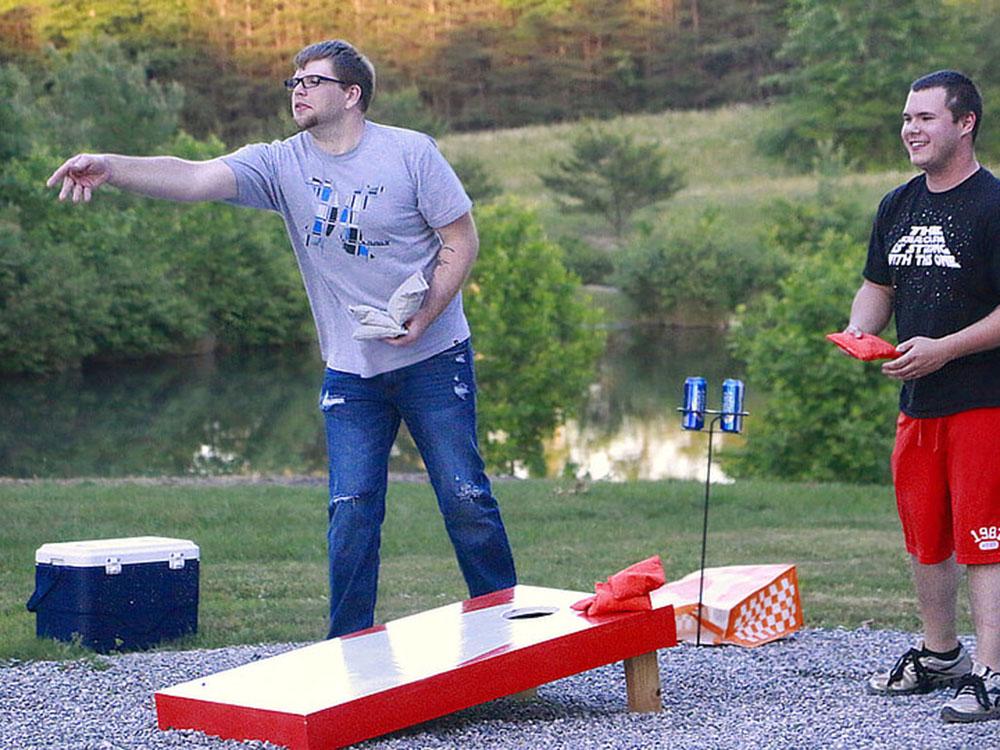 Two men playing corn hole at MOUNTAIN GLEN RV PARK & CAMPGROUND