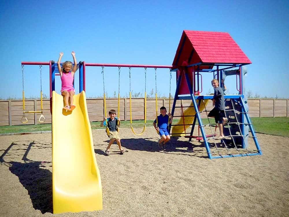 Playground with swing set at OASIS RV RESORT