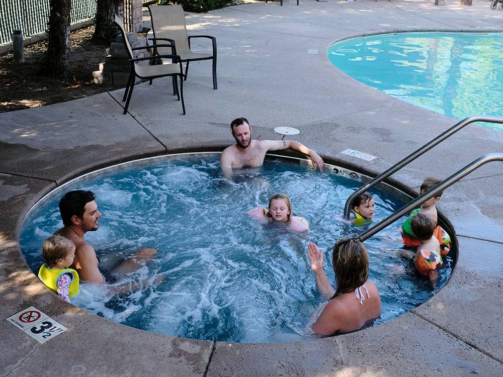 A couple of families enjoying the hot tub at BAKERSFIELD RIVER RUN RV PARK