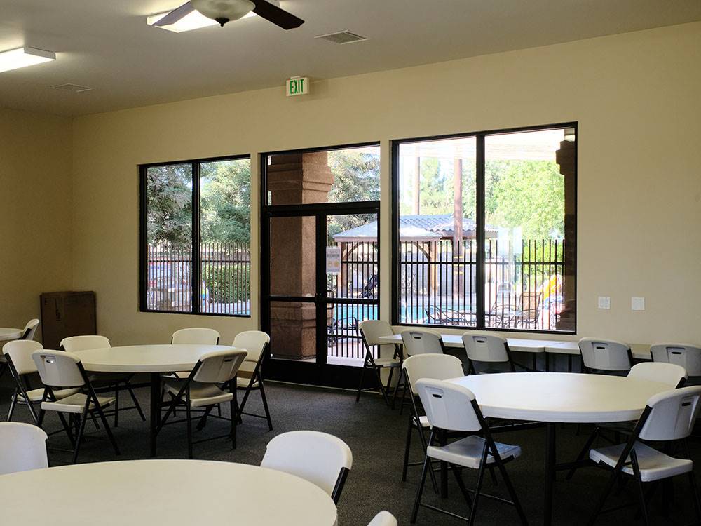 The recreation room with tables and chairs at BAKERSFIELD RIVER RUN RV PARK