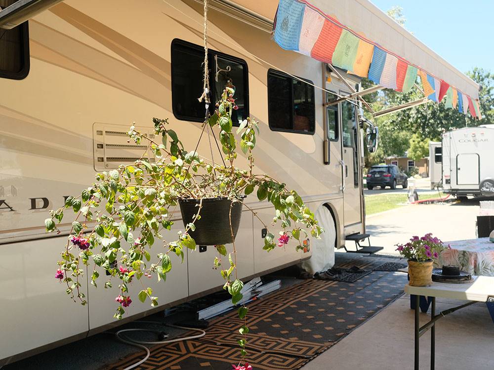 A flower planter hanging next to a RV parked at BAKERSFIELD RIVER RUN RV PARK