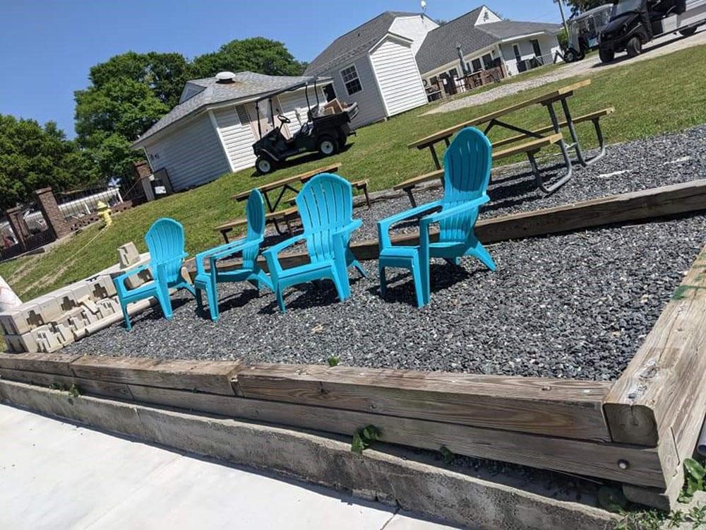 Four blue chairs next to picnic benches at BRIARCLIFFE RV RESORT