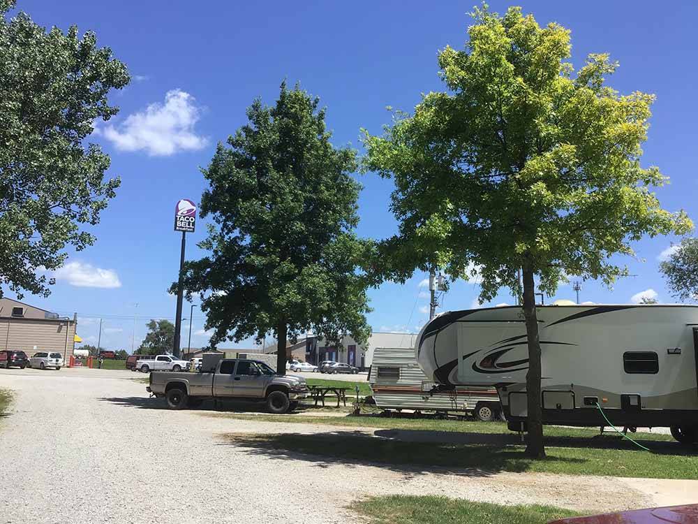 A line of gravel RV sites with a Taco Bell in the background at QUAIL RIDGE RV PARK