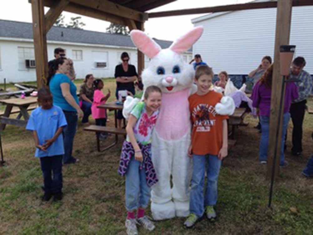 Kids taking a photo with the Easter bunny at FOUR OAKS LODGING & RV RESORT