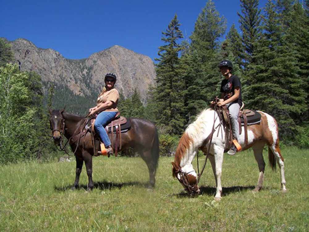 A couple of people riding horses at SKY MOUNTAIN RESORT RV PARK