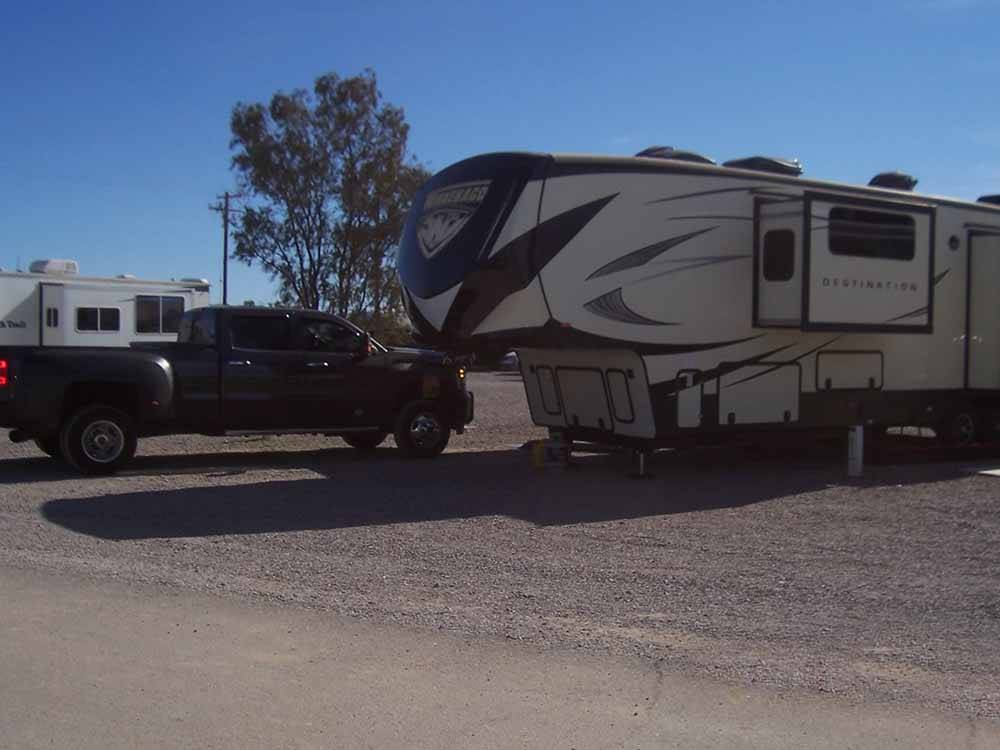 A fifth wheel trailer and truck in an RV site at 3 DREAMERS RV PARK