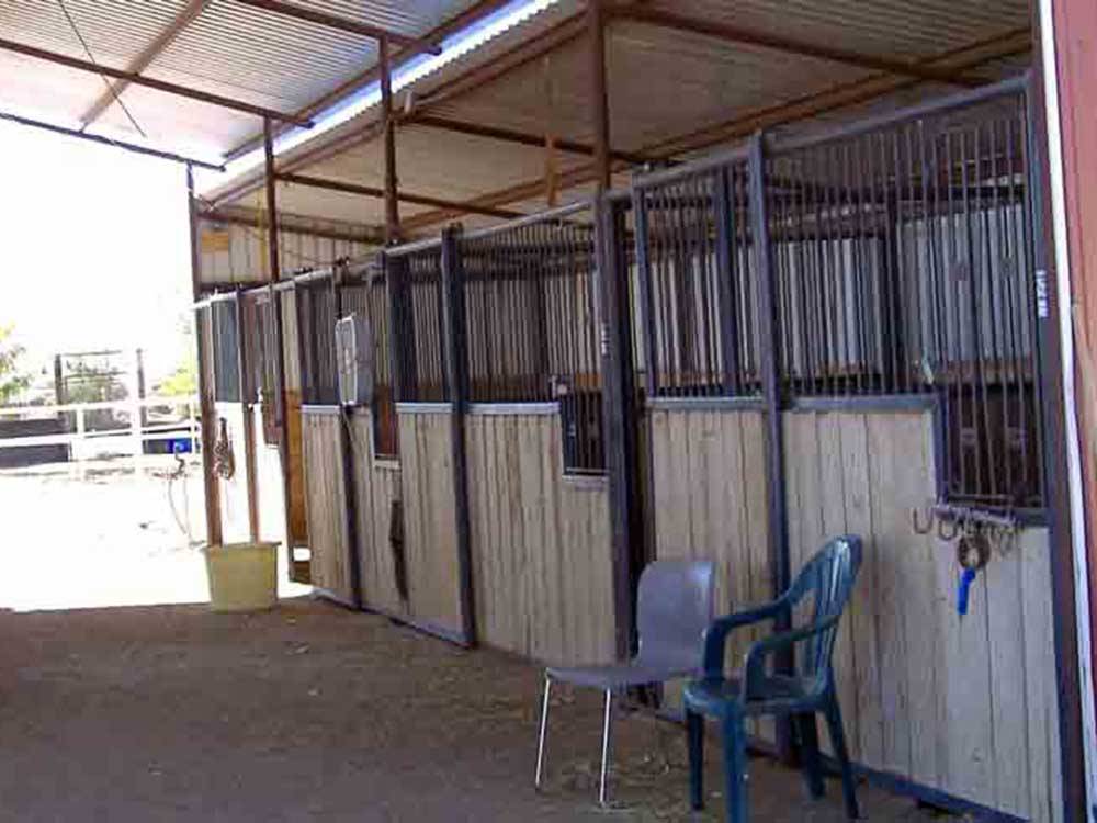 Two chairs next to the horse stables at KIVA RV PARK & HORSE MOTEL