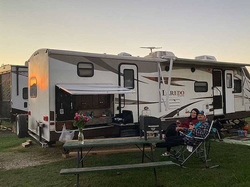 Couple watching TV outside their RV at COYOTE VIEW RV PARK & RV REPAIR