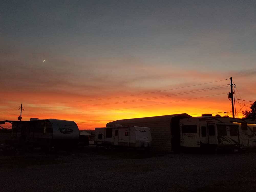 RVs parked in sites at sunset at COYOTE VIEW RV PARK & RV REPAIR