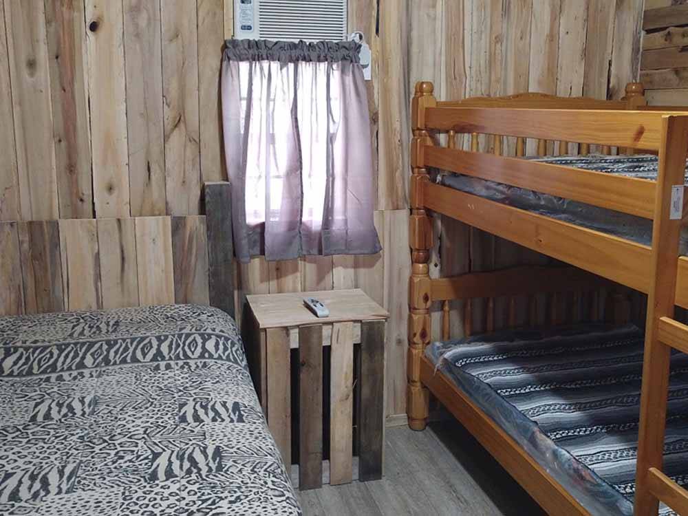 Bunk beds and a wood crate inside of a cabin at R & D FAMILY CAMPGROUND