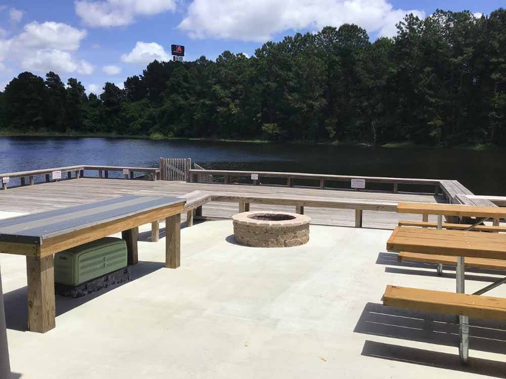 A fire pit and sitting area by the water at COASTAL GEORGIA RV RESORT