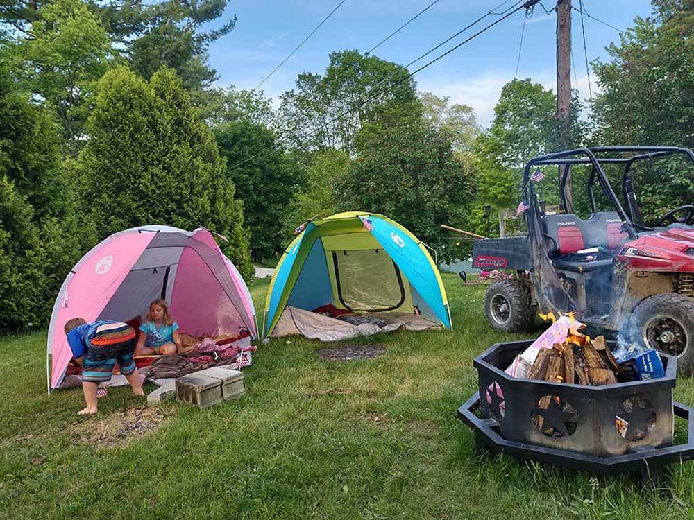 Tents near fire pit and ATV at COOL-LEA CAMP