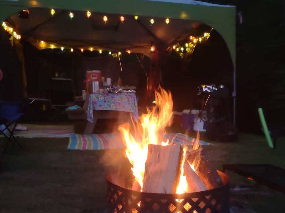 Fire pit and gazebo at night at COOL-LEA CAMP