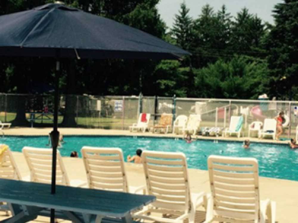Outdoor chairs facing the pool at ATLANTIC BLUEBERRY RV PARK