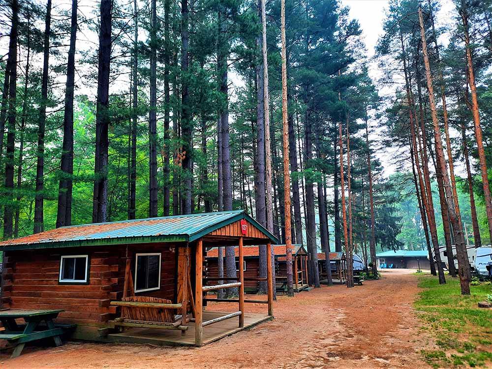 A row of rustic rental cabins at APPLE CREEK CAMPGROUND & RV PARK