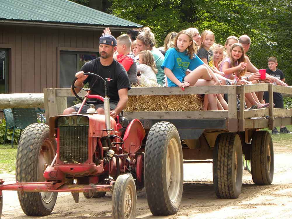 People on a hay ride being pulled by a tractor at APPLE CREEK CAMPGROUND & RV PARK