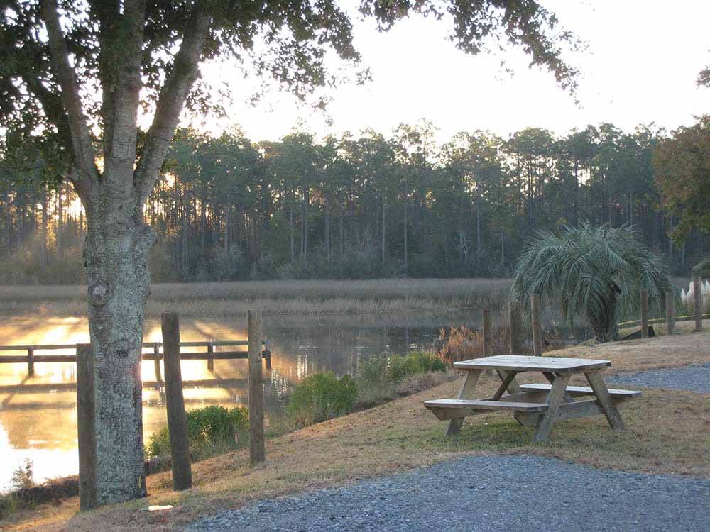 A picnic table by the water at sunset at AVALON LANDING RV PARK
