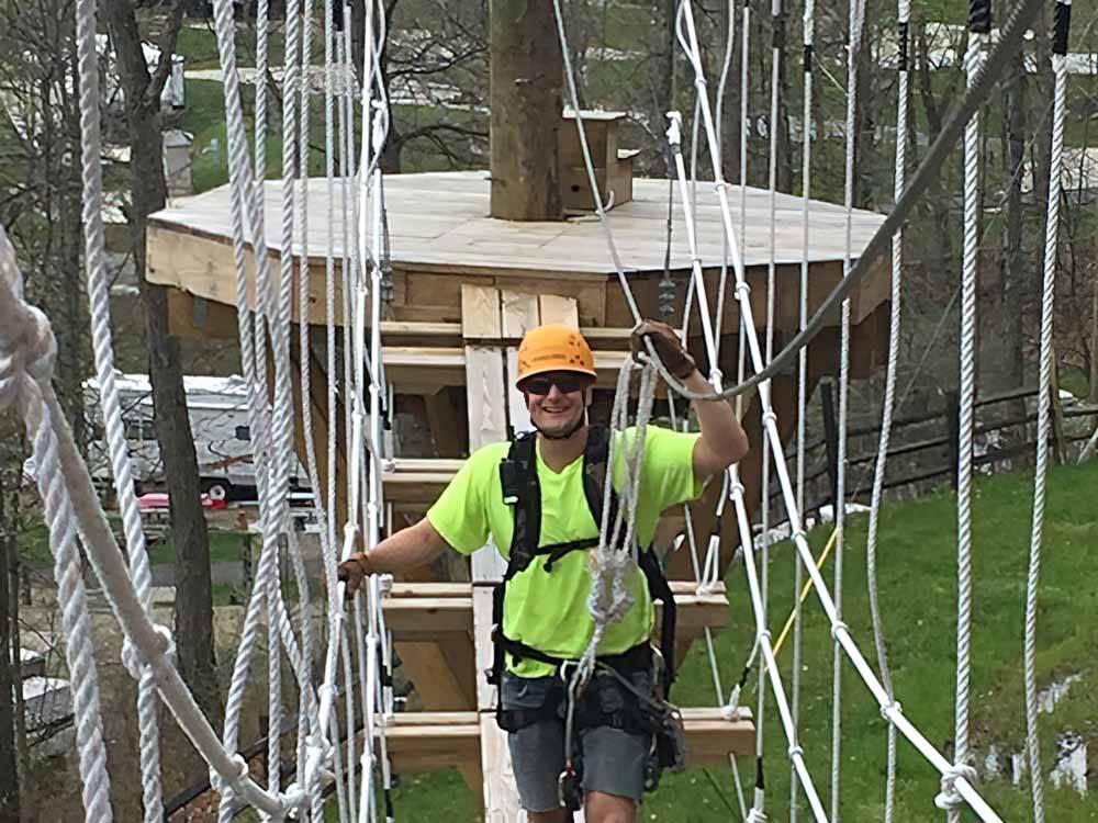 A man on the ropes course at WOOD'S TALL TIMBER RESORT