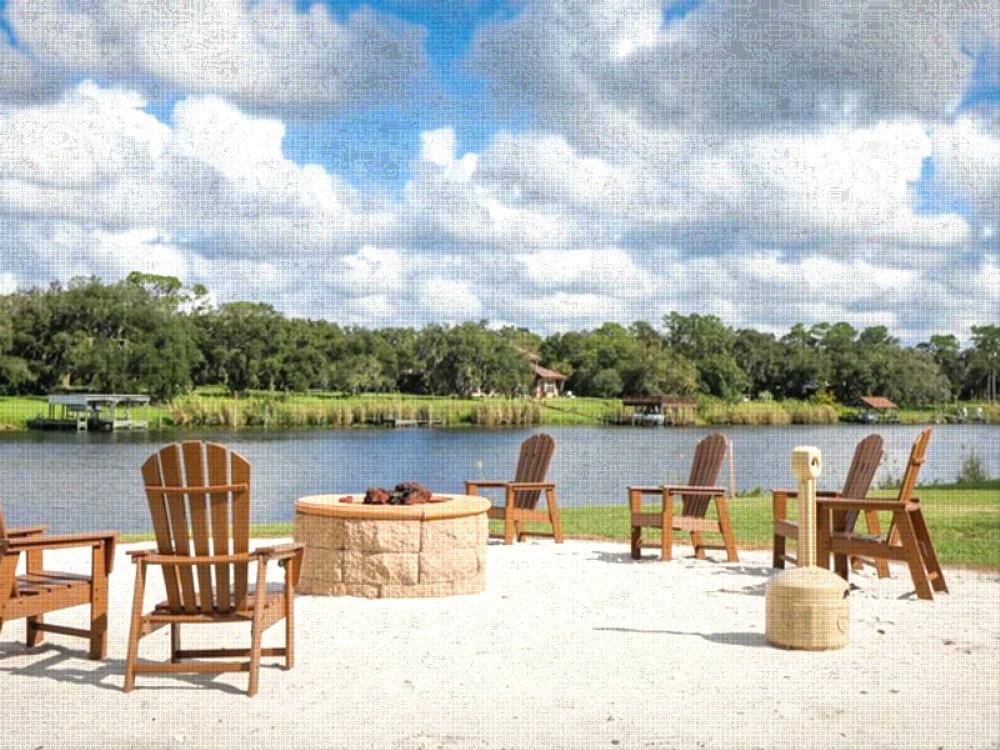 Chair's around fire pit with lake view at Moss Landing RV Resort