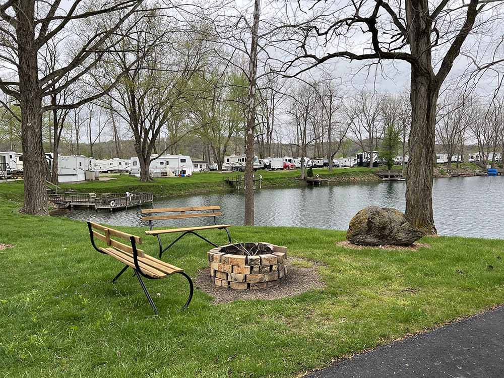 A fire pit with benches by the water at LAKEVIEW RV PARK