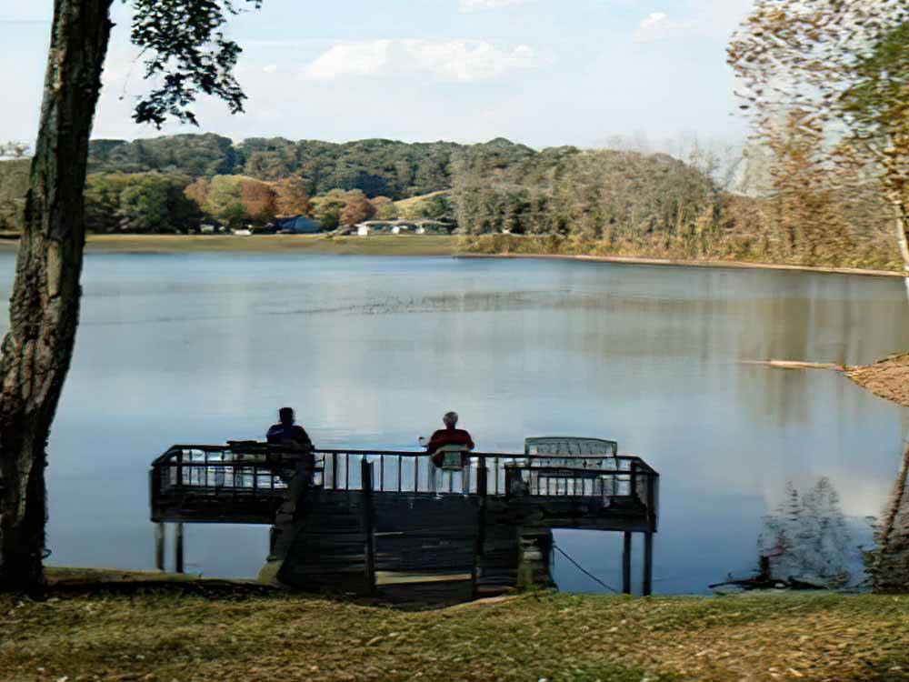 A couple of people sitting on a dock at LAKEVIEW RV PARK