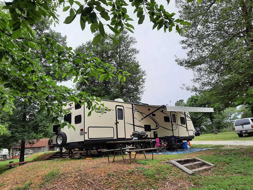 A travel trailer in a grassy RV site at PARKERS CROSSROADS CAMPGROUND