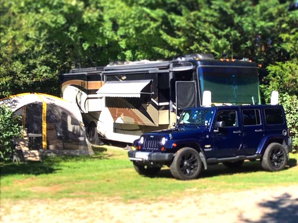 A motorhome parked under trees at SHADY KNOLL CAMPGROUND