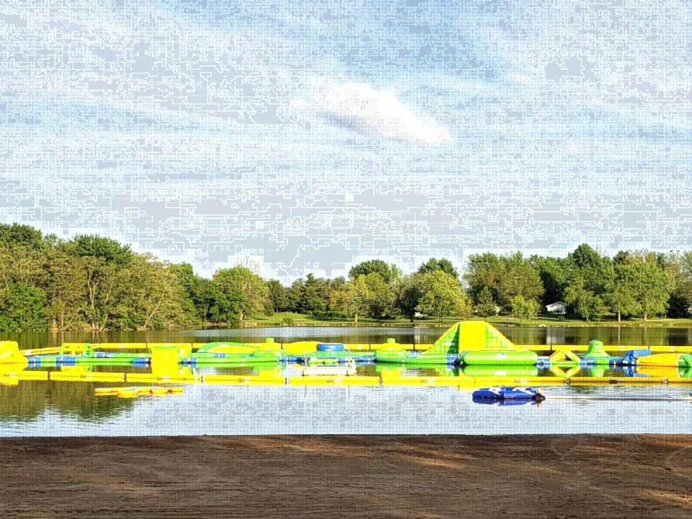 Lake with water play area on it at Yogi Bear's Jellystone Park at Pine Lakes