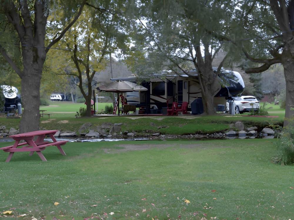 Parked RV with lake view at Woodstream Campsite