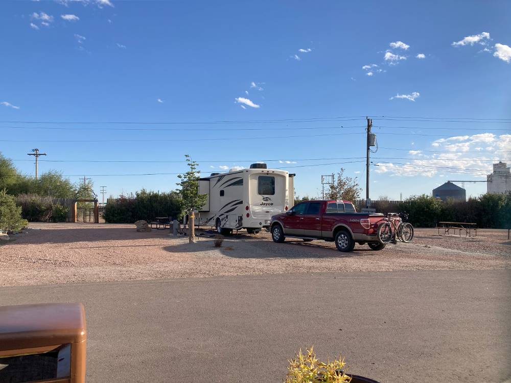 An RV with a red truck in tow