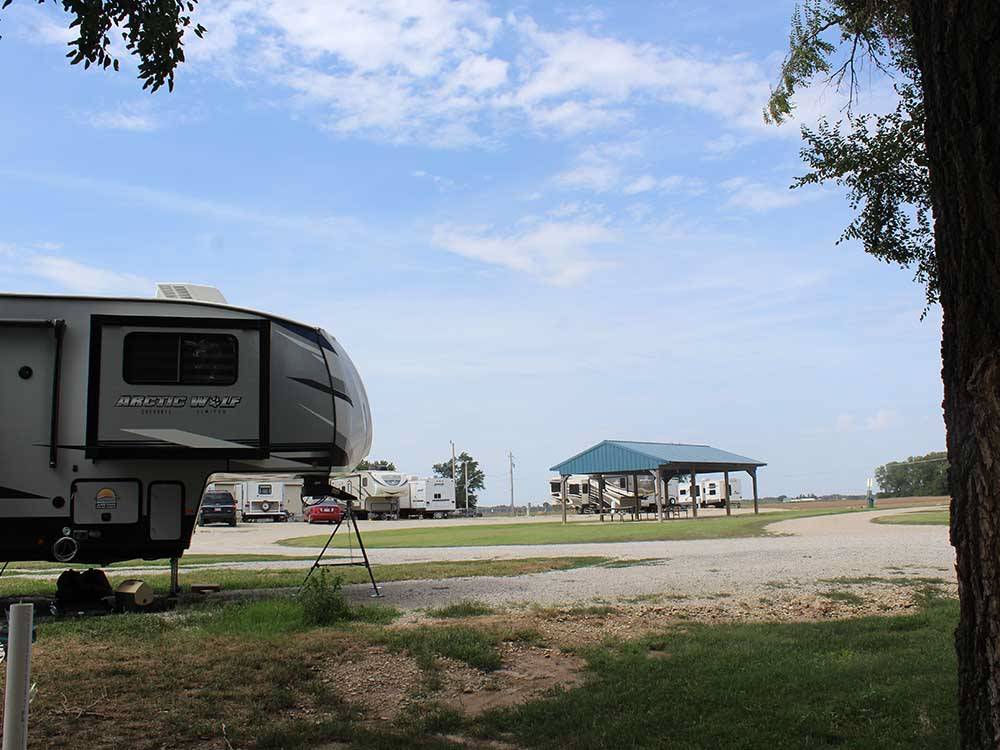 Fifth-wheel with canopy, blue sky background at COVERED WAGON RV RESORT