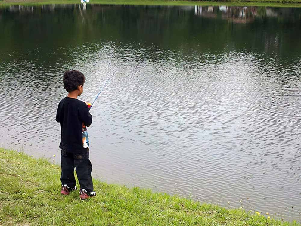 A small boy fishing in the lake at EVERGREEN LAKE PARK