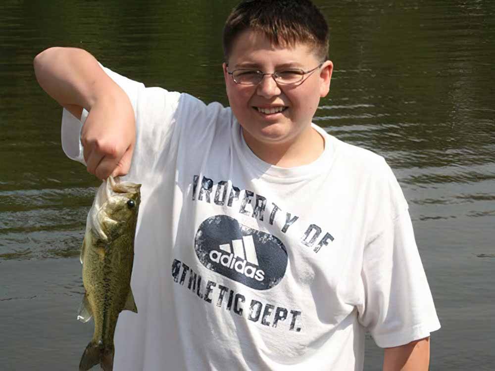 A boy holding a fish at EVERGREEN LAKE PARK