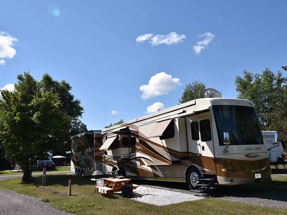 A motorhome in a gravel RV site at CAMP HITHER HILLS