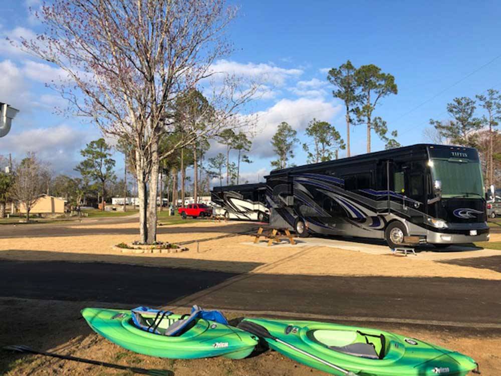 Class A motorhome parked in site with kayaks next to it at FLORIDA CAVERNS RV RESORT AT MERRITT'S MILL POND