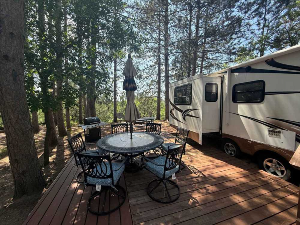 RV parked in site with deck and table