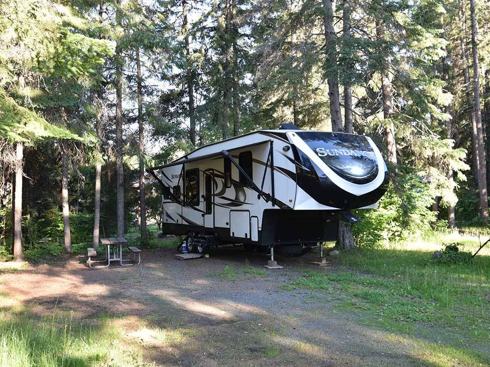 A fifth wheel trailer in a back in RV site at HAPPY LAND RV PARK