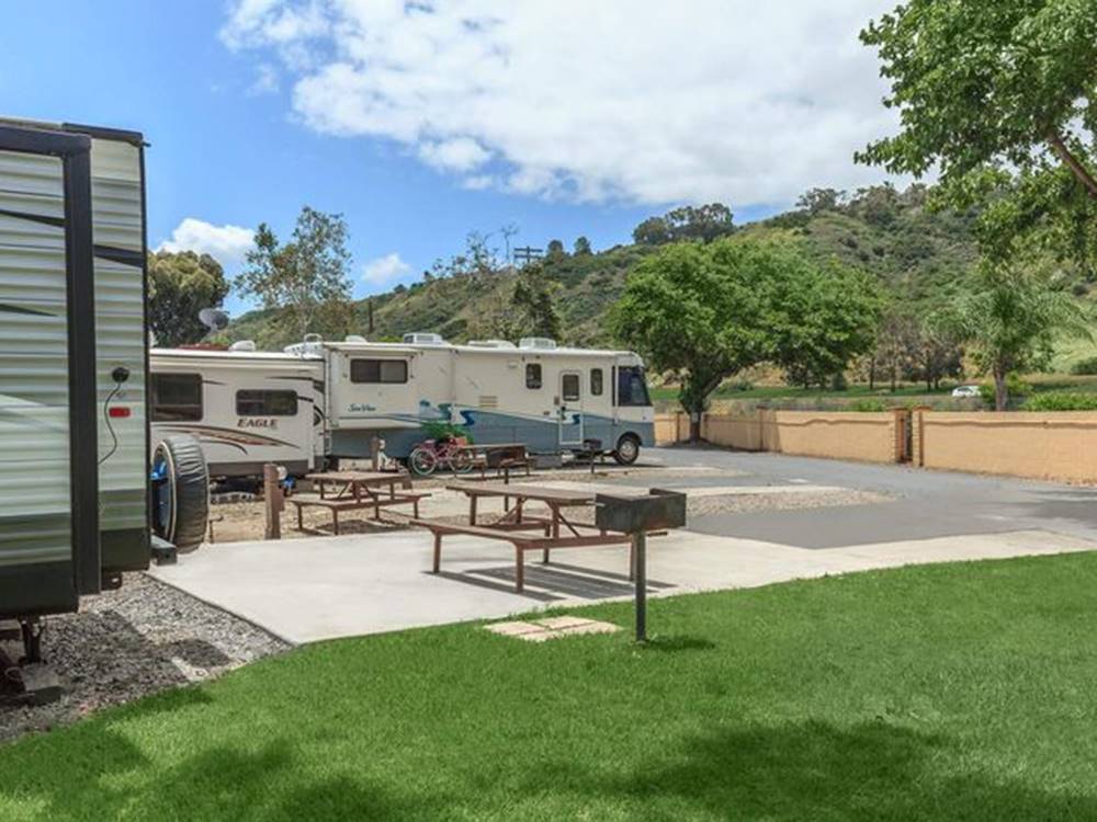 RVs parked near grill and picnic tables