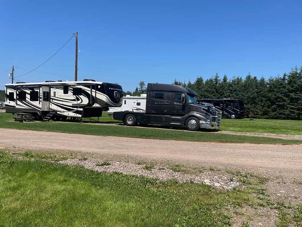 A diesel truck and a fifth wheel in a gravel site at SCOTIA PINE CAMPGROUND